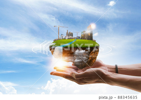 Hands holding city of industrial island model. Hands holding city of industrial island model. 88345635