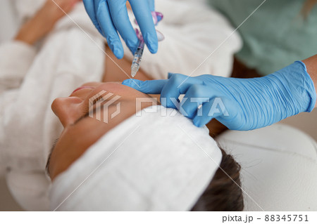 Hands of expert beautician filling female face with hyaluronic acid 88345751