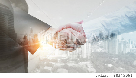 Business partner shaking hands in city with double exposure of interface data. Teamwork concept. Business partner shaking hands in city with double exposure of interface data. Teamwork concept. 88345961