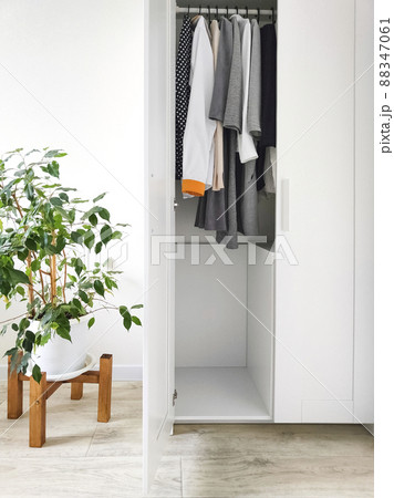 Wardrobe with basic clothes in room scandi interior. Neutral colors. Wardrobe with basic clothes in room scandi interior. Neutral colors. 88347061