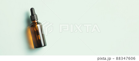 Amber glass dropper bottle with black lid on green background. Skincare products , natural cosmetic. Beauty concept for face and body care. Banner Amber glass dropper bottle with black lid on green background. Skincare products , natural cosmetic. Beauty concept for face and body care. Banner 88347606