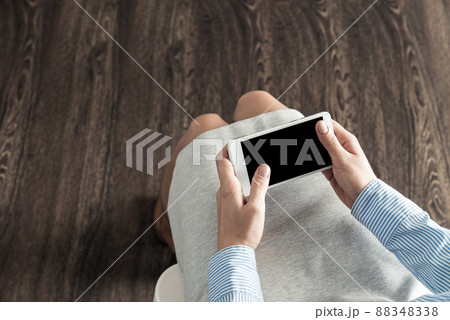 business woman with cell phone on her lap 88348338
