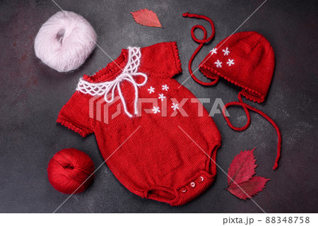 Clothing for a newborn baby knitted from red threads 88348758