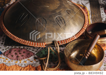 Tongue drum and Tibetan bowls lying on the carpet 88349492