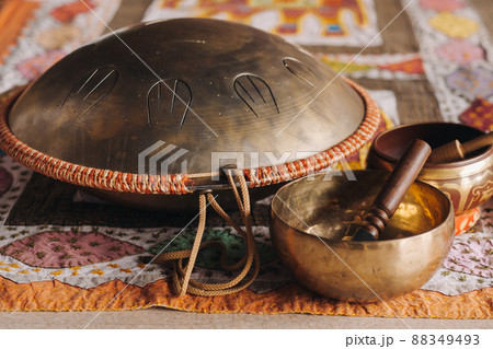 Tongue drum and Tibetan bowls lying on the carpet Tongue drum and Tibetan bowls lying on the carpet 88349493