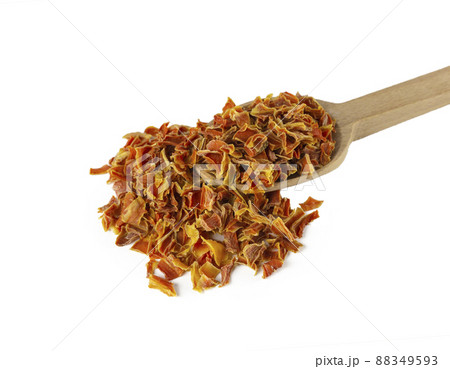 dried carrot pieces on wooden spoon isolated on white background. Spices and food ingredients. 88349593