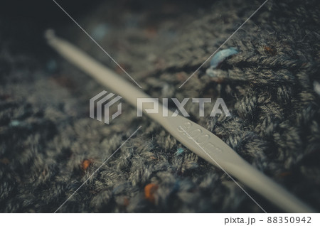 Knitting hook 300mm. Natural yarn made of wool. His hobby is hand knitting. Selective focus, black background Knitting hook 300mm. Natural yarn made of wool. His hobby is hand knitting. Selective focus, black background 88350942