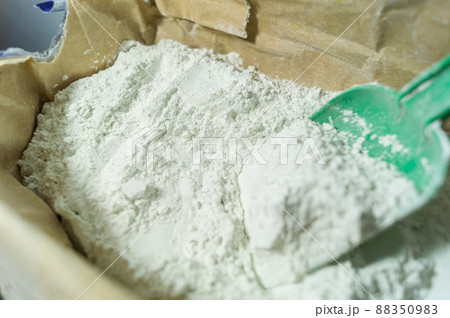 White plaster in an open paper bag. Finishing dry mixture for leveling walls and ceilings. Repair in the house with your own hands. DIY. Selective focus 88350983