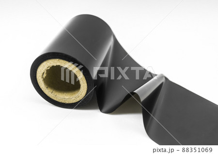 Black thermal transfer ribbon - TTR. Wax thermo ribbon on cardboard reel for barcode. Supply material for printing industry. Selective focus, isolated on white 88351069