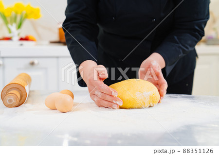 women's hands knead dough. flour and eggs on table women's hands knead dough. flour and eggs on table 88351126