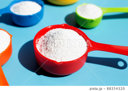Detergent powder with measuring spoon for clothes washing. Laundry concept. Detergent powder with measuring spoon for clothes washing. Laundry concept. 88354320