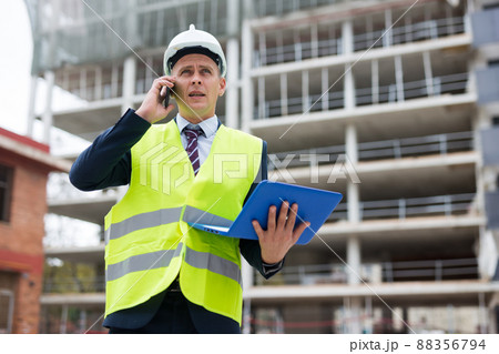 Engineer with laptop talking on phone outdoors 88356794