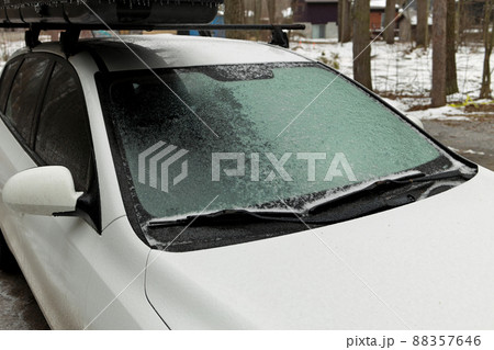 Freezing Rain Creates a Layer of Ice and Coats a Passenger Vehicle. Close up of Windshield 88357646