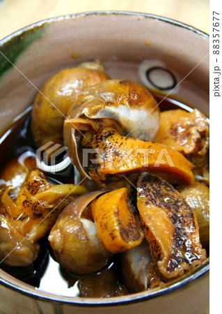 新鮮なツブ貝を醤油ベースの煮付けにして萩焼の小鉢に盛った画像。 88357677