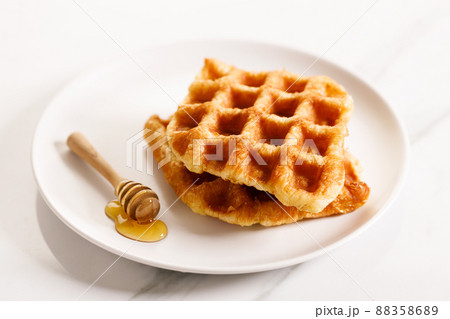 Croissant waffle or Croffle served in a white plate.. Croissant waffle or Croffle served in a white plate.. 88358689