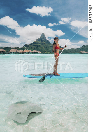 SUP Stand-up paddle board woman wwimming with stingrays tourist tour activity happy Asian woman on Bora Bora island beach at Tahiti overwater bungalow hotel, holiday travel vacation SUP Stand-up paddle board woman wwimming with stingrays tourist tour activity happy Asian woman on Bora Bora island beach at Tahiti overwater bungalow hotel, holiday travel vacation 88358982