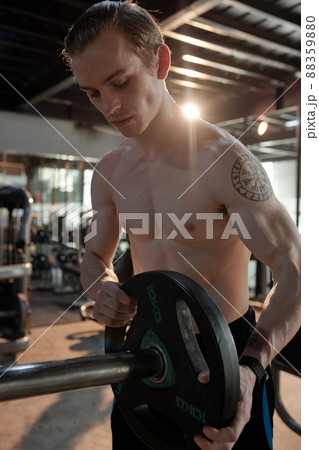 Sportsman Putting More Weight on Barbbell 88359880