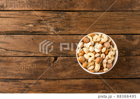 Various kinds of nuts (almonds, pistachios, peanuts, hazelnuts and cashews) in bowl on wooden table. Close up Various kinds of nuts (almonds, pistachios, peanuts, hazelnuts and cashews) in bowl on wooden table. Close up 88366495