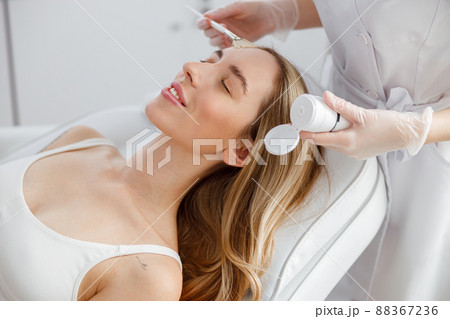 Young woman having skincare procedure in beauty salon 88367236