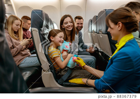 Family with child talking with stewardess in airplane Family with child talking with stewardess in airplane 88367379
