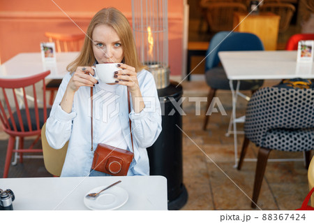 Young woman having cup of coffee in cafe Young woman having cup of coffee in cafe 88367424