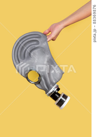 Hand holding gas mask on yellow backgroundの写真素材 [88369876] - PIXTA