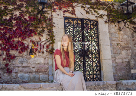 Woman tourist on background of beautiful view of the island of St. Stephen, Sveti Stefan on the Budva Riviera, Budva, Montenegro. Travel to Montenegro concept Woman tourist on background of beautiful view of the island of St. Stephen, Sveti Stefan on the Budva Riviera, Budva, Montenegro. Travel to Montenegro concept 88373772
