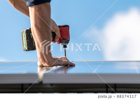 Unidentified man attaching solar panel to the roof rack Unidentified man attaching solar panel to the roof rack 88374317
