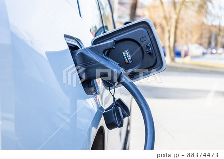 Electric vehicle or EV car with the power cable supply plugged in 88374473