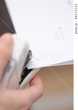 書類をホッチキスで纒めるOLの女性の手 88375353