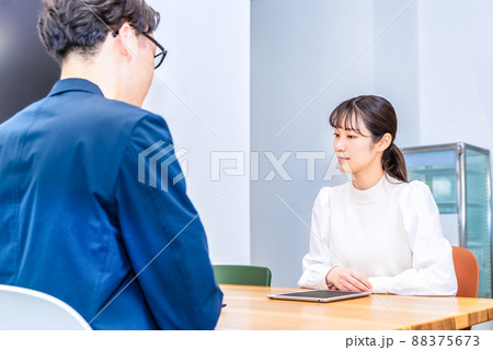 フリーアドレスオフィスでミーティングをするビジネスマンとビジネスウーマン 88375673