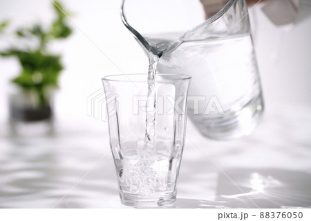 氷の入ったグラスに水を注ぐ手元 氷の入ったグラスに水を注ぐ手元 88376050