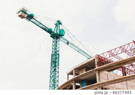 Construction crane with clouds sky background at construction site. tower crane with blue sky Green lifting crane on a cloudy blue sky background. A Look Up of The Tower Crane. Construction crane with clouds sky background at construction site. tower crane with blue sky Green lifting crane on a cloudy blue sky background. A Look Up of The Tower Crane. 88377995