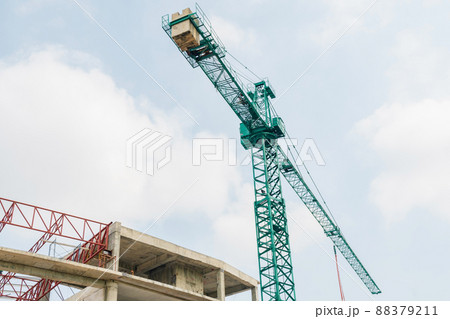 The construction crane with the cloud sky background at the construction site. The Tower Crane against a blue sky. Yellow hoisting crane on blue sky background with clouds, close up of The Tower Crane The construction crane with the cloud sky background at the construction site. The Tower Crane against a blue sky. Yellow hoisting crane on blue sky background with clouds, close up of The Tower Crane 88379211