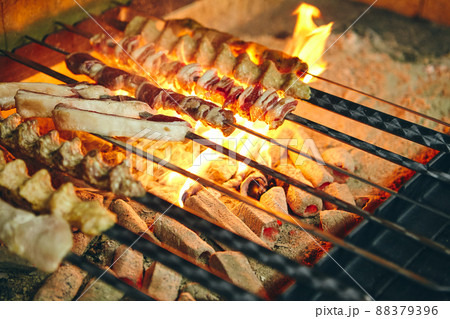 Shish kebab on skewers from different types of meat is fried on the grill Shish kebab on skewers from different types of meat is fried on the grill 88379396