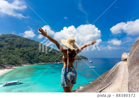 back view of women wearing a straw hat standing in view Beautiful sea and blue sky at Similan island, Phuket,Thailand. 88380372