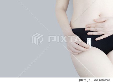 Vaginal or rectal candle in the hands of a woman against the background of the abdomen and underwear. Treatment vaginal infections, candidiasis, thrush and sexually transmitted infections 88380898