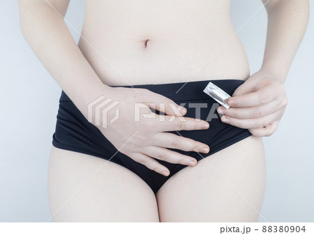 Vaginal or rectal candle in the hands of a woman against the background of the abdomen and underwear. Treatment vaginal infections, candidiasis, thrush and sexually transmitted infections 88380904