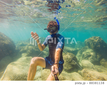 young men snorkeling exploring underwater coral reef landscape background in the deep blue ocean with colorful fish and marine life young men snorkeling exploring underwater coral reef landscape background in the deep blue ocean with colorful fish and marine life 88381138