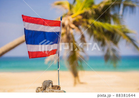 Waving Thailand flag in the sunny blue sky with summer beach background. Vacation theme, holiday concept Waving Thailand flag in the sunny blue sky with summer beach background. Vacation theme, holiday concept 88381644