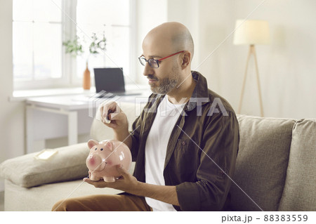 Provident man put coin in piggybank 88383559