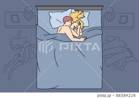 Happy couple cuddle in bed after sex 88384228