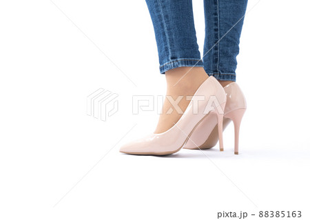 Slender female legs in patent leather shoes with high heels. Dark blue jeans. Fashion and Style. Side view Slender female legs in patent leather shoes with high heels. Dark blue jeans. Fashion and Style. Side view 88385163
