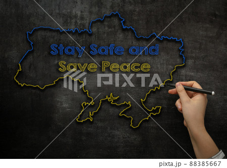 girl writes text stay safe and save peace in Ukraine on the blackboard  88385667