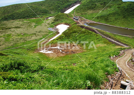 活火山 秋田駒ケ岳 男女岳登山道から阿弥陀池小屋と雪渓を見下ろす 活火山 秋田駒ケ岳 男女岳登山道から阿弥陀池小屋と雪渓を見下ろす 88388312