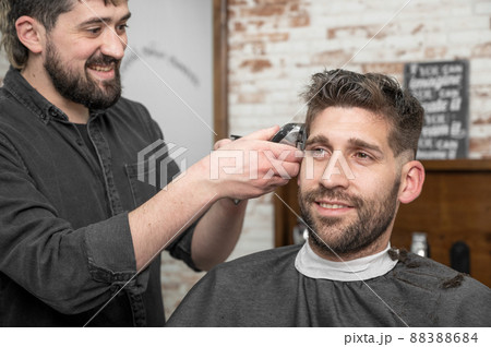 Closeup of happy man getting an haircut, in hair salon. High quality photo Closeup of happy man getting an haircut, in hair salon. High quality photo 88388684