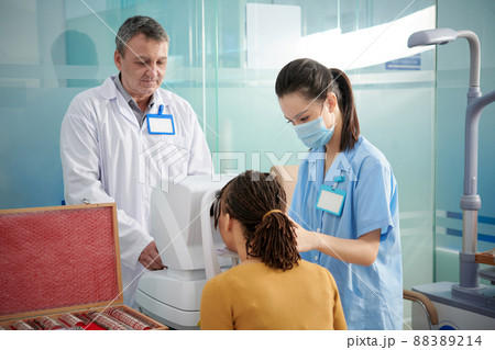 Medical Team Using Autorefractor 88389214