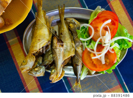 Tasty fried scad served with tomatoes, onion and letucce Tasty fried scad served with tomatoes, onion and letucce 88391486