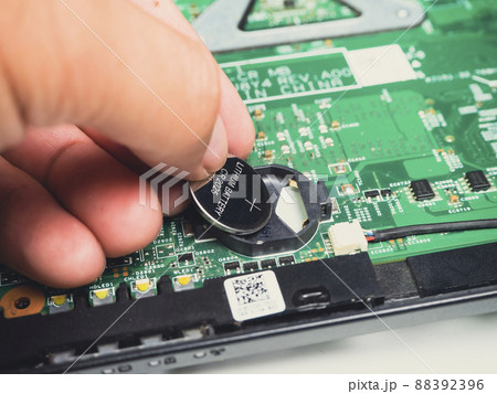 Computer mechanic insert lithium battery CR2025 to CMOS backup battery slot on computer motherboard 88392396