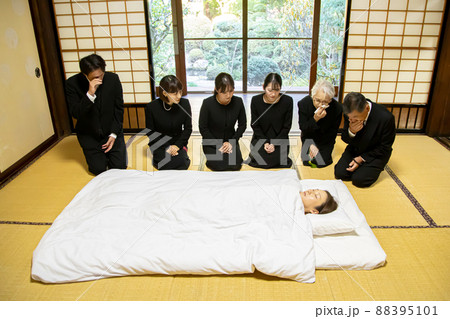お葬式・お通夜で布団を囲み故人を弔う遺族 お葬式・お通夜で布団を囲み故人を弔う遺族 88395101